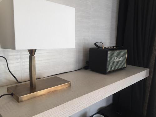 une table avec une lampe et une radio sur celle-ci dans l'établissement Hôtel Cannes Centre Univers, à Cannes