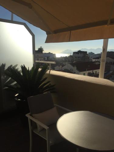 une table et une chaise sur un balcon avec une plante dans l'établissement Hôtel Cannes Centre Univers, à Cannes