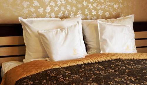 a bed with white pillows on top of it at Pension Casa Grande in Baile Felix