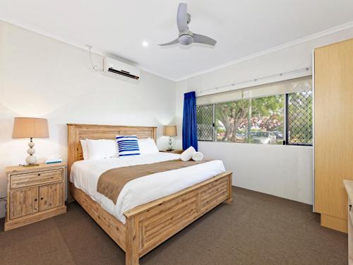 a bedroom with a large bed and a window at Riviera Motel Bundaberg in Bundaberg