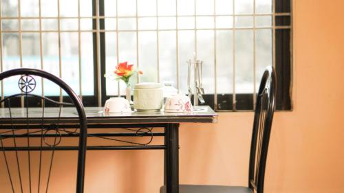 a table with a vase with a flower on it next to a window at Hotel Mountain View - Lakeside Pokhara in Pokhara