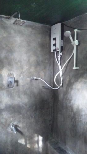 a bathroom with a hair dryer on the wall at Pitaramba Lodge in Bentota