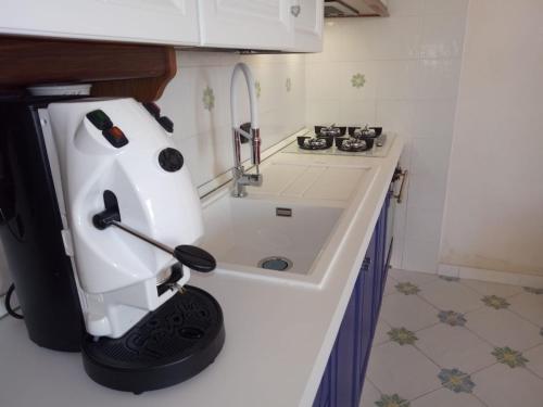 a small kitchen with a white appliance on a counter at Villetta Cala Rotonda in Favignana