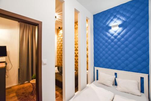 ブダペストにあるBluebel Luxory Apartment in the city centerの青いアクセントの壁(ベッド付)