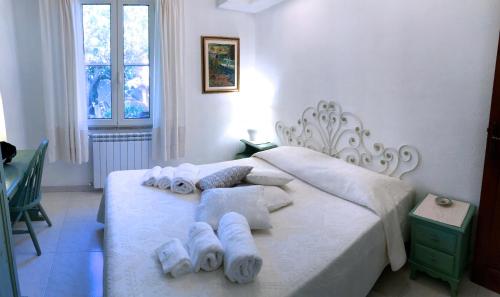 a bedroom with a white bed with towels on it at Villa Mica in La Maddalena