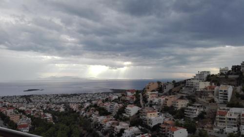 アテネにあるPanoramic Voula's View Apartmentの曇りの日の海と市街の景色