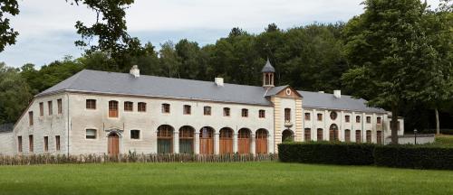 a large white building with trees in the background at B&B Baron’s House Neerijse-Leuven in Neerijse