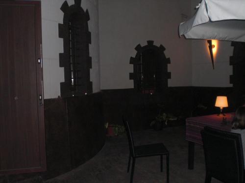 a room with a table and a chair and a table and a lamp at Casa Rural el Castillico in Yecla