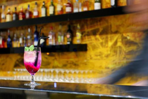 a drink in a glass sitting on top of a bar at Hotel Hamilton SPA & Wellness in Świnoujście