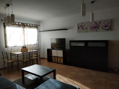 een woonkamer met een tafel en een televisie bij VV EL CHARCO, El Hierro in La Caleta