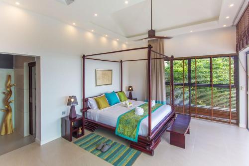 a bedroom with a canopy bed and a large window at Stunning sea view villa Lamai Koh Samui in Lamai