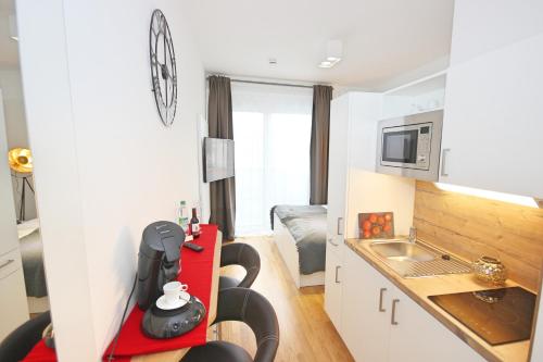 a small kitchen with a red table in a room at Apart Hotel Messe Munich - my room Apartments in Munich
