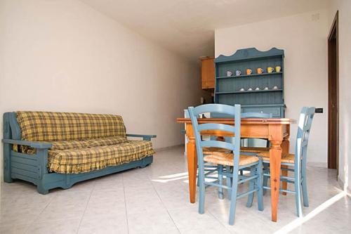 ein Esszimmer mit Tisch und Stühlen und einer Couch in der Unterkunft Le Residenze di Santa Costanza - Il Lentisco in San Vincenzo