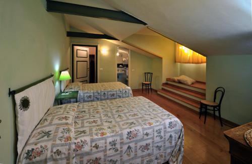 a bedroom with two beds and a room with a staircase at Agriturismo La Sovana in Sarteano