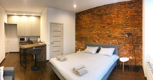 a bedroom with a brick wall and a bed at VIP Apartment Ploscha Rynok in Lviv