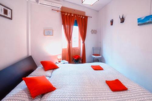 a bedroom with a bed with red pillows on it at Milhouse in Cagliari