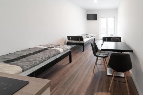 Habitación con cama, mesa y sillas. en Monteurzimmer Berlin Pankow mit Dachterrasse - Nur 10 min. von der A10 - 3 Zimmer/ 7 Betten en Berlín