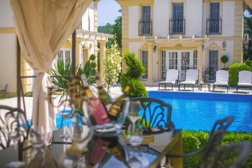 a table with glasses and chairs next to a pool at Luxury-Villas in Sopron