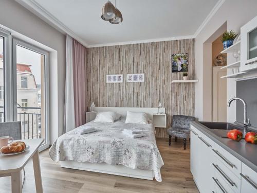 マリアーンスケー・ラーズニェにあるWITH LOVE Marienbad Ap. Dvorakovaの白いベッドルーム(ベッド1台付)、キッチンが備わります。