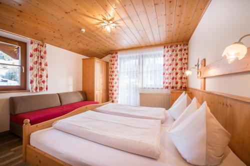 une chambre avec un grand lit et un canapé dans l'établissement Aparthotel Markushof, à Wagrain