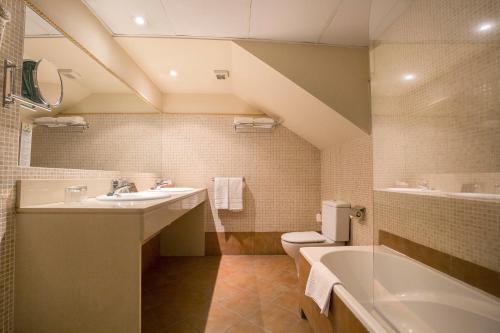 La salle de bains est pourvue d'un lavabo, d'une baignoire et de toilettes. dans l'établissement Hotel Himàlaia Soldeu, à Soldeu