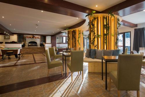a living room with a table and chairs and a piano at Hotel Piolets Soldeu Centre by Nexta in Soldeu
