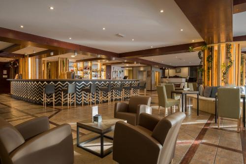 a bar in a hotel with chairs and tables at Hotel Piolets Soldeu Centre by Nexta in Soldeu