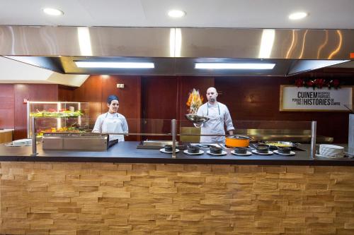 two chefs standing in a kitchen preparing food at Hotel Piolets Soldeu Centre by Nexta in Soldeu