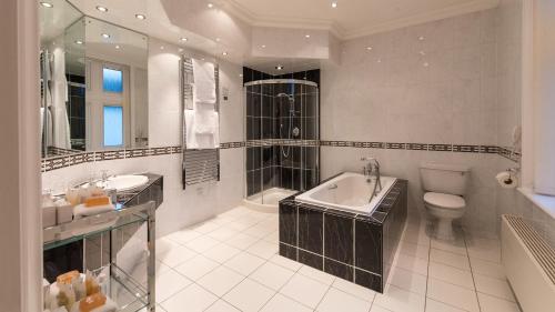 a bathroom with a sink, toilet and bathtub at The Victoria Hotel in Sidmouth