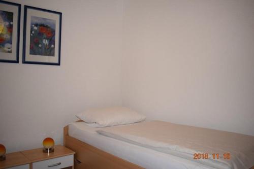 Ferienwohnung Weinlaube في Bergrheinfeld: غرفة نوم صغيرة مع سرير وطاولة