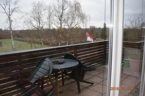 Ferienwohnung Weinlaube في Bergrheinfeld: طاولة وكراسي على شرفة مع نافذة