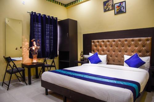 a bedroom with a large bed with blue pillows at Udee's Homestay in Agra