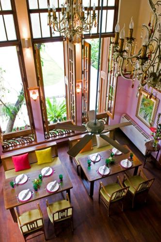 a dining room with tables and chairs and a chandelier at Ariyasom Villa in Bangkok