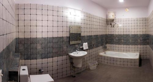 un bagno con lavandino, WC e vasca di Udee's Homestay ad Agra