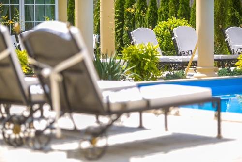 a group of chairs sitting in front of a pool at Luxury-Villas in Sopron