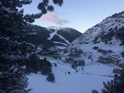 a snow covered mountain with a town and a valley at Hotel Roc de St Miquel & Apartment in Soldeu