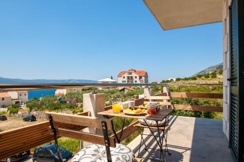 a balcony with a table and chairs and a view of the ocean at Sunrise Apartments Bol in Bol