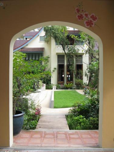 an archway leading into a garden with a lawn at Ariyasom Villa in Bangkok