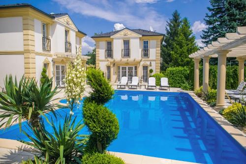 a swimming pool in front of a house at Luxury-Villas in Sopron