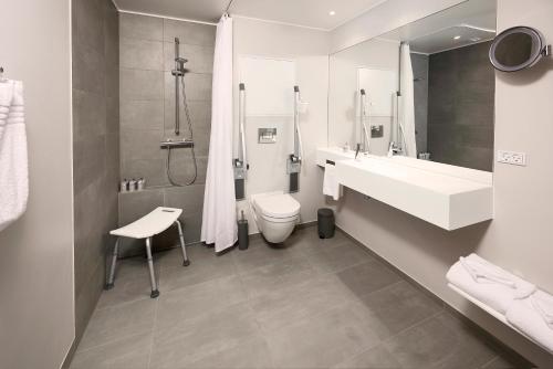 a bathroom with a toilet, sink, and bathtub at Hotel Odeon in Odense