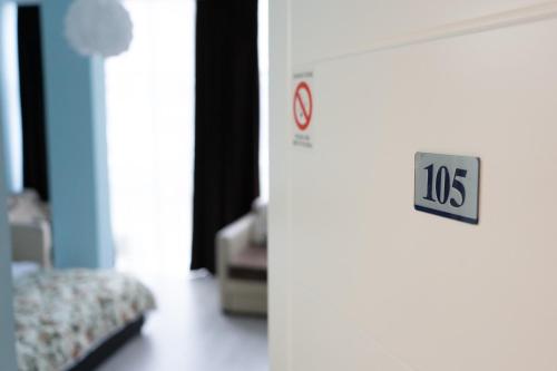 a door with a sign on it in a room at Garni Hotel Lotos in Niš