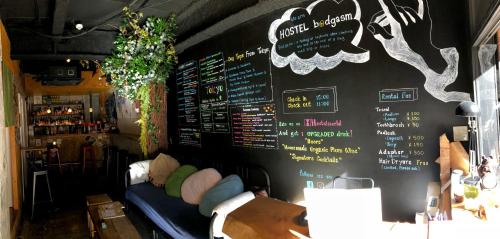 Hostel Bedgasm في طوكيو: مطعم مع قائمة طعام على الحائط مع أريكة