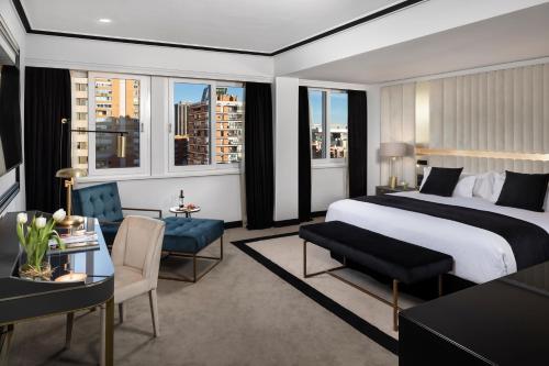 a bedroom with a king sized bed and a living room at Melia Castilla in Madrid