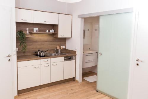 uma cozinha com armários brancos e um lavatório em Scheinerhaus em Laa an der Thaya