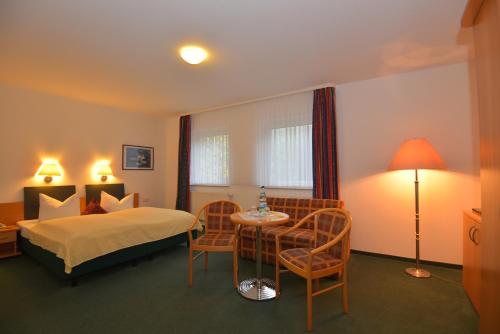 una camera d'albergo con letto, tavolo e sedie di Hotel Am Wald -GARNI- a Elgersburg