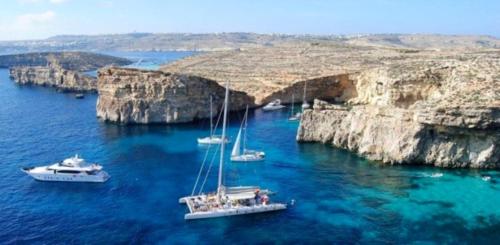 a group of boats in the water near cliffs at Villa Naxxar Malta in Naxxar