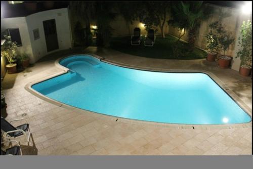 a large swimming pool in a backyard at night at Malta Villa in Naxxar