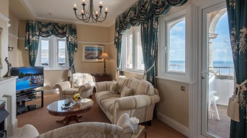 a living room with a couch and chairs and a tv at The Victoria Hotel in Sidmouth