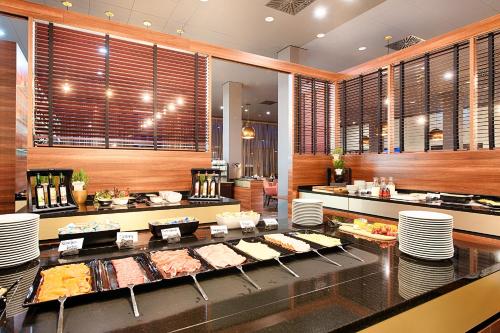a buffet line with food on display in a restaurant at Welcome Hotel Neckarsulm in Neckarsulm
