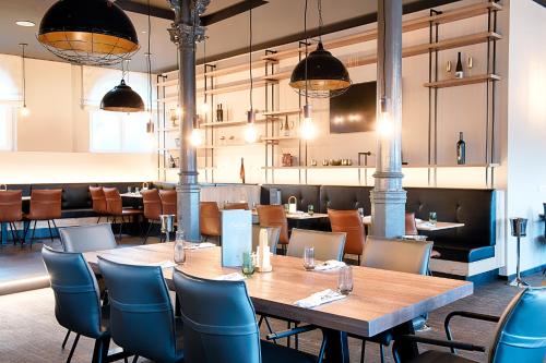 a restaurant with a wooden table and chairs at Welcome Hotel Neckarsulm in Neckarsulm